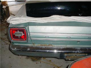 1972 Ford Ranchero - The rear section of a teal vehicle is visible, a chrome bumper and a distinctive rectangular taillight assembly.