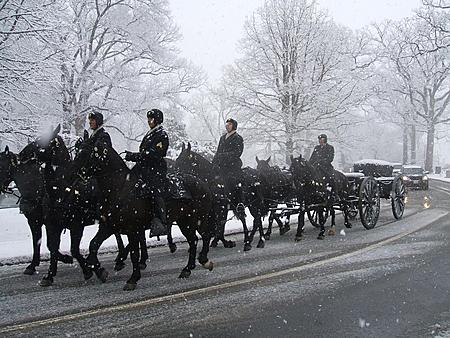 1982 Toyota 4Runner - A horse-drawn hearse moves down a road during a snowfall, with riders in uniform.