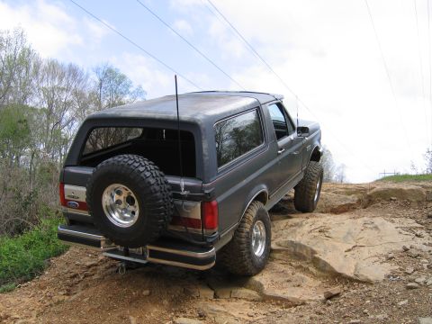 1989 Ford Bronco - This Ford Bronco is navigating a rocky terrain, showing its off-road capabilities.