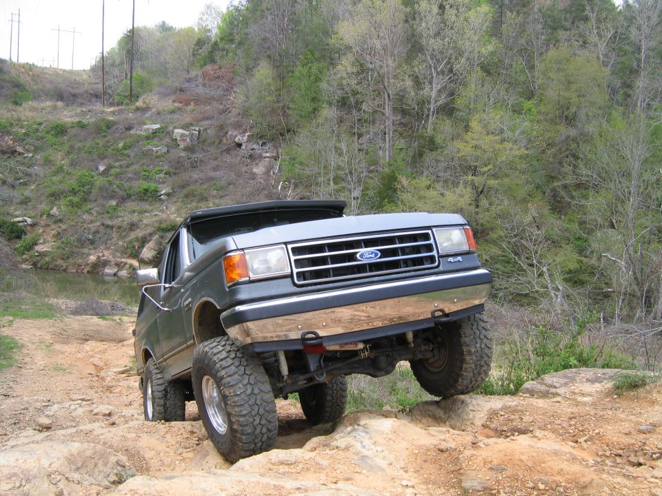Gray 1989 Ford Bronco climbing rocks