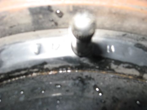1964 Chevrolet Corvette - Close-up of a metal part, possibly a wheel hub or brake drum, with visible markings.