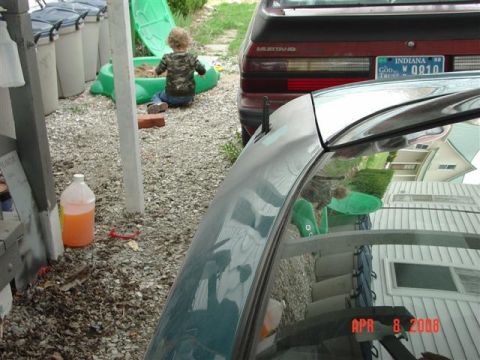 1993 Ford Probe - Rear view of a red Ford Mustang with an Indiana license plate, parked next to another vehicle.