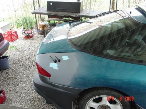 1993 Ford Probe - The rear of a teal car shows primer spots on the bodywork and a red taillight.