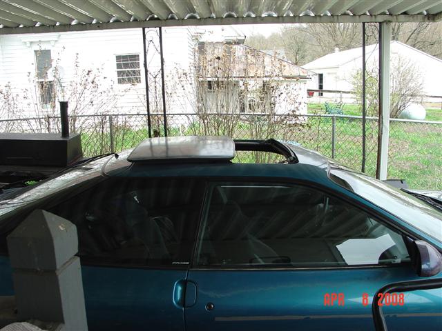 Teal coupe side view with sunroof open