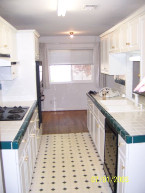 1991 Ford Bronco - This is a photo of a kitchen with white cabinets and green countertops, a window at the far end.
