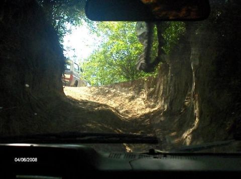 1987 Ford Bronco - Driving through a challenging off-road trail with another vehicle ahead on the path.