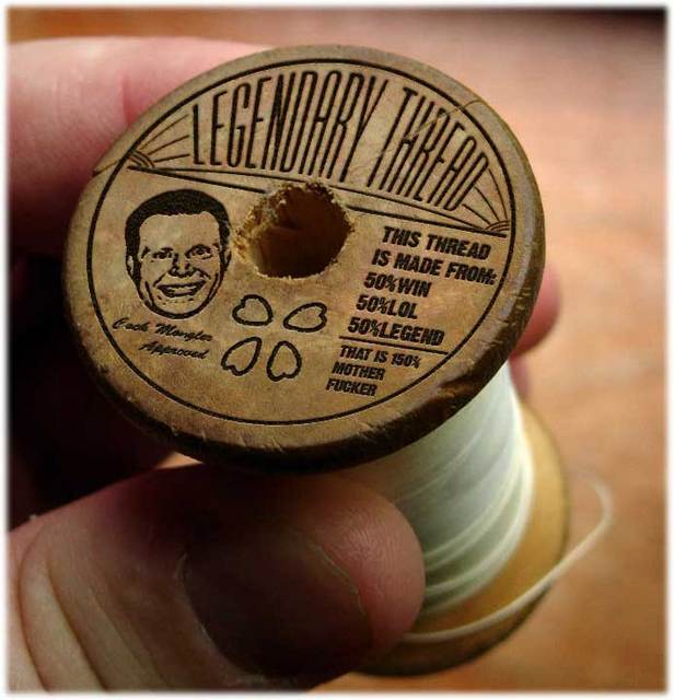 Wooden spool of thread with "Legendary Thread" text and a drawing of a man
