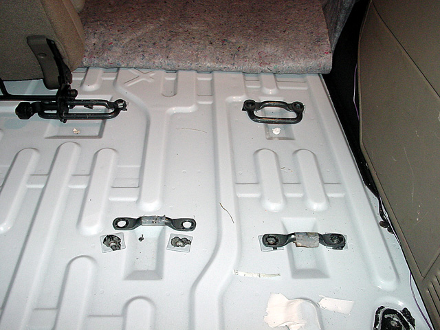 Cargo area floor with tie-down loops and seat mounting hardware visible