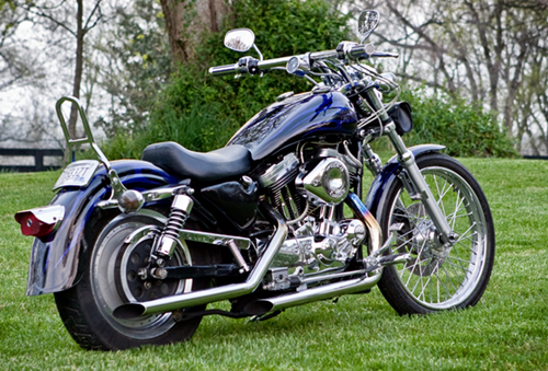 Blue motorcycle with chrome accents parked on grass