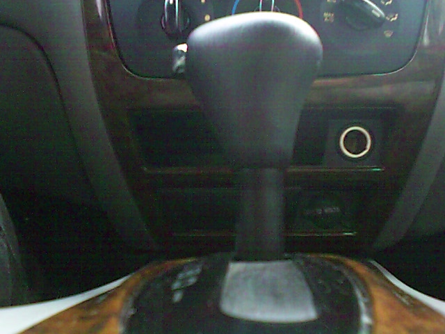 Black automatic shifter and woodgrain center console with 12V outlet in a Mercury Sable interior