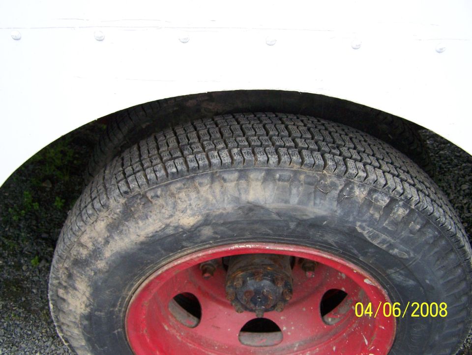 Close-up of a worn tire on a red wheel on a delivery truck