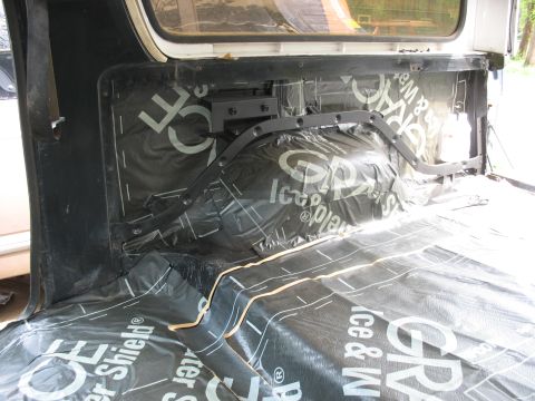 1978 Ford Bronco - Soundproofing material is installed in the interior of a vehicle, covering the wheel well and floor area.