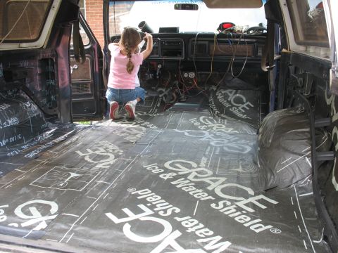 1978 Ford Bronco - Child installs soundproofing material inside a 1978 Ford Bronco's interior.