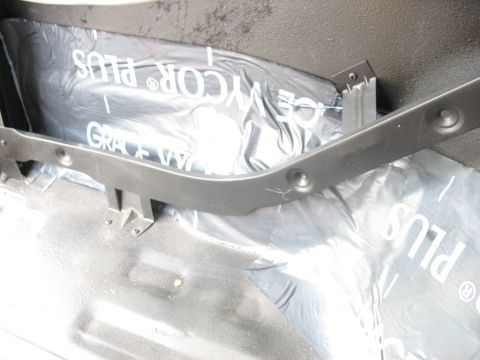 1978 Ford Bronco - Waterproofing material is visible inside a vehicle, beneath a dark gray trim piece.