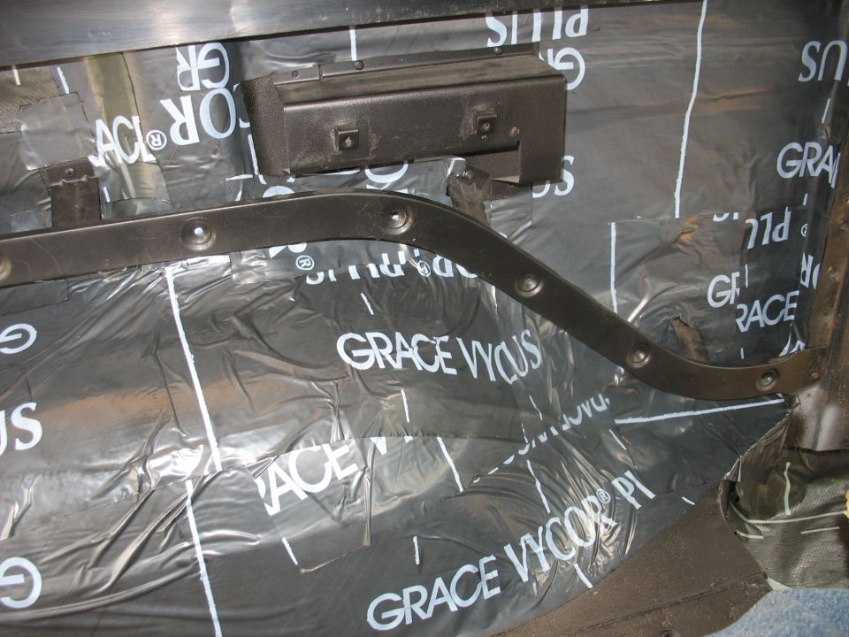 close-up of black sound dampening material with 'GRACE VYCOR' text installed on vehicle interior panels