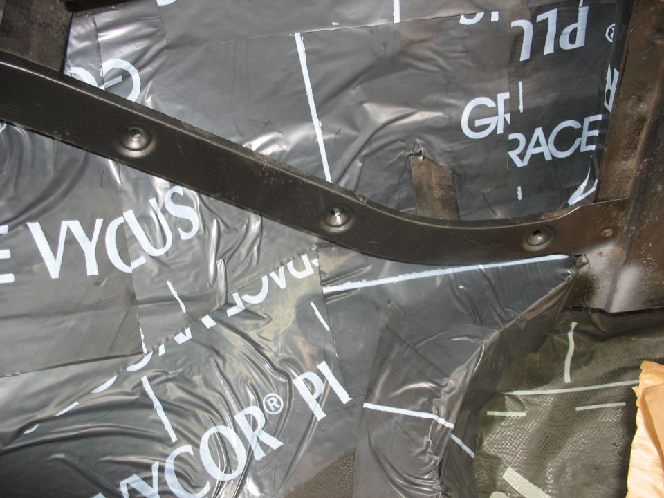 Interior view of black plastic sheeting with white text 'VYCOR' and 'GRACE' on the floor of a vehicle