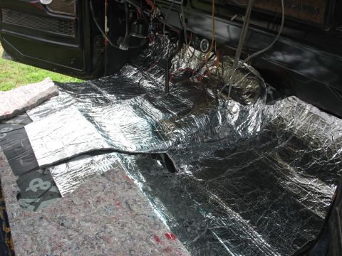 1978 Ford Bronco - Soundproofing material is laid out on the floor of a vehicle's interior during installation.