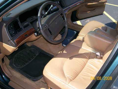 1995 Mercury Grand Marquis - Interior of a sedan showing tan leather seats, woodgrain dashboard accents, dark steering wheel and floor mats; dated 04/08/2008.