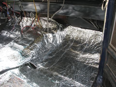 1978 Ford Bronco - Soundproofing material covers the floor and lower dashboard of a vehicle interior during installation.