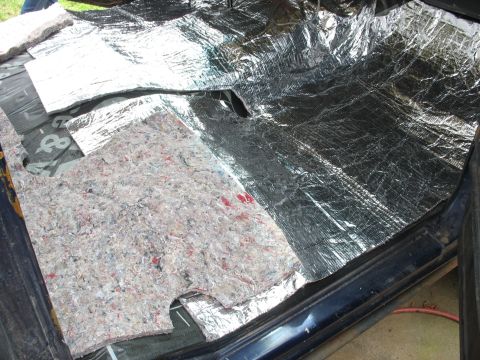1978 Ford Bronco - Installing sound deadening material on the floor of a vehicle, covering the metal panels.