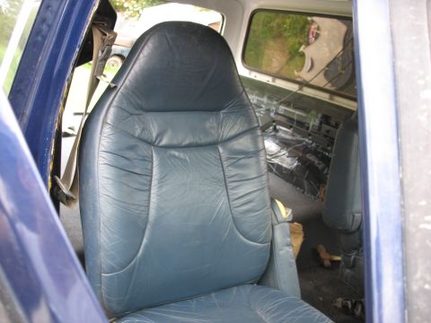 1978 Ford Bronco - Interior view of a vehicle showing blue seats and sound deadening material in the cargo area.