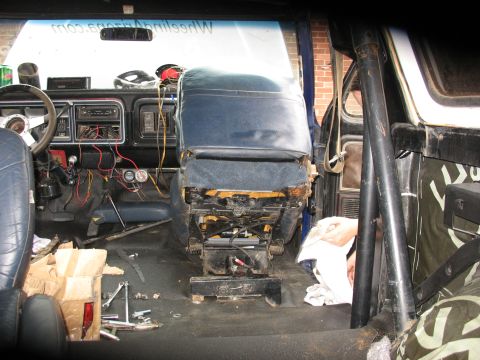 1978 Ford Bronco - The interior of a vehicle shows exposed wiring and a removed seat, suggesting ongoing work or modification.