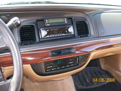 1995 Mercury Grand Marquis - Wood-trim center dash with an aftermarket JVC head unit, a digital compass reading 24, and a climate panel showing 67F.