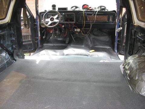 1978 Ford Bronco - The interior of a vehicle is shown with the dashboard and floor carpeting, suggesting a restoration or modification project is underway.
