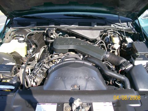 1995 Mercury Grand Marquis - The engine bay of a vehicle, the air intake and fan shroud with visible text warnings.