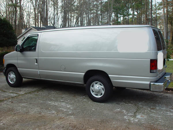 Silver Ford cargo van in side profile parked on a concrete driveway