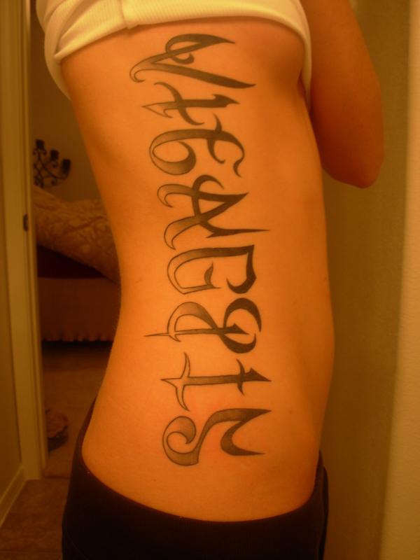 Tattoo of script text on a person's side