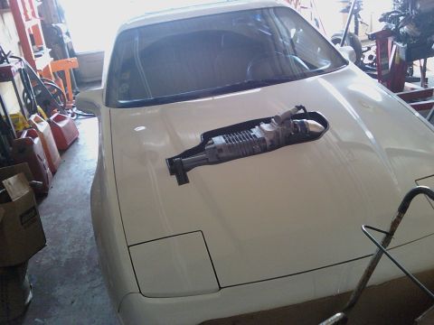 1991 Ford Probe - A 1991 Ford Probe is shown with a supercharger placed on its hood.