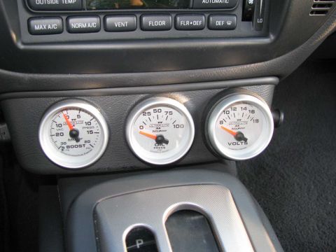 2003 Mercury Marauder - Close-up of aftermarket boost, oil pressure, and voltage gauges installed in a vehicle's interior.