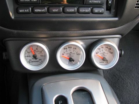 2003 Mercury Marauder - Close-up of aftermarket boost, oil pressure, and voltage gauges installed in a vehicle's interior.
