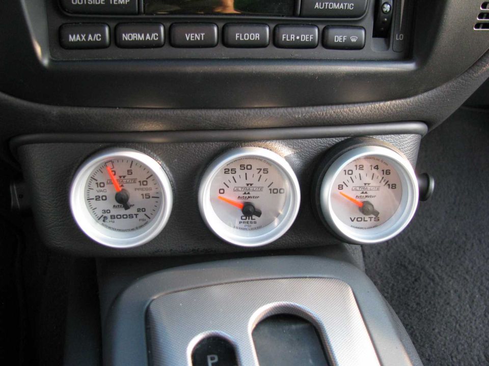 Three Auto Meter Ultra-Lite gauges (boost, oil press, volts) in center console