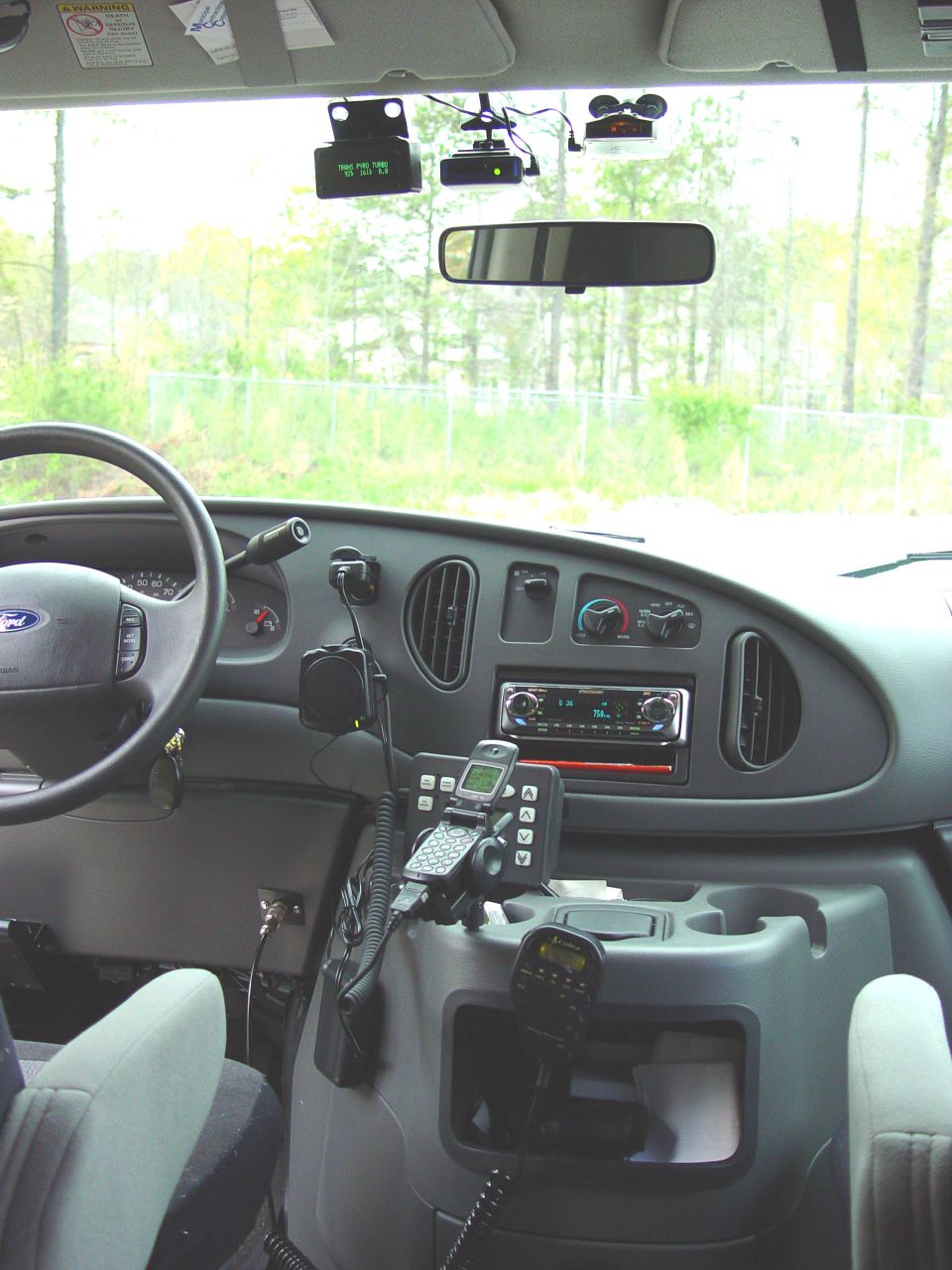 Ford van interior dashboard with steering wheel, stereo and two-way radio equipment
