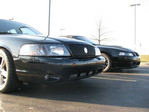 2003 Mercury Marauder - Two black sedans, including a 2003 Mercury Marauder, are parked outdoors on pavement.
