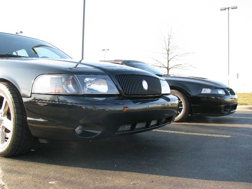 Front corner of a black 2003 Mercury Marauder next to another black sedan