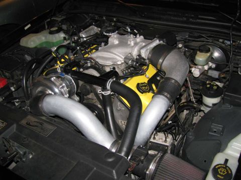 2003 Mercury Marauder - Engine bay with a turbocharger and custom modifications. The yellow valve covers are prominent.