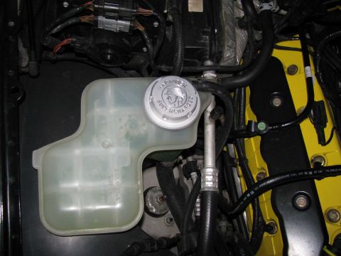 2003 Mercury Marauder - Close-up of a coolant reservoir and supercharger cap in an engine bay.