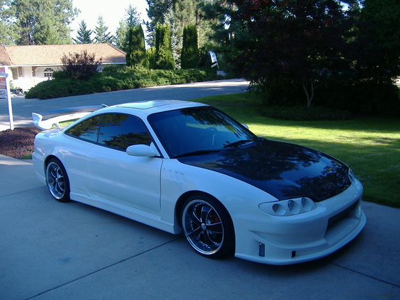 1995 Ford Probe, white with black hood and aftermarket spoiler, parked on driveway