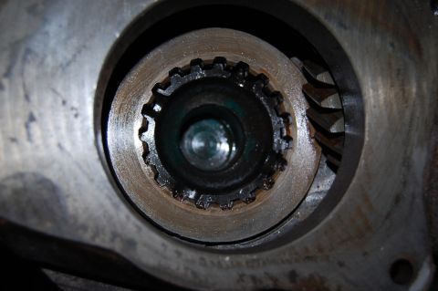 1994 Ford Bronco - A close-up view reveals a splined shaft and gear teeth within a metal housing, likely a component of a vehicle's drivetrain.