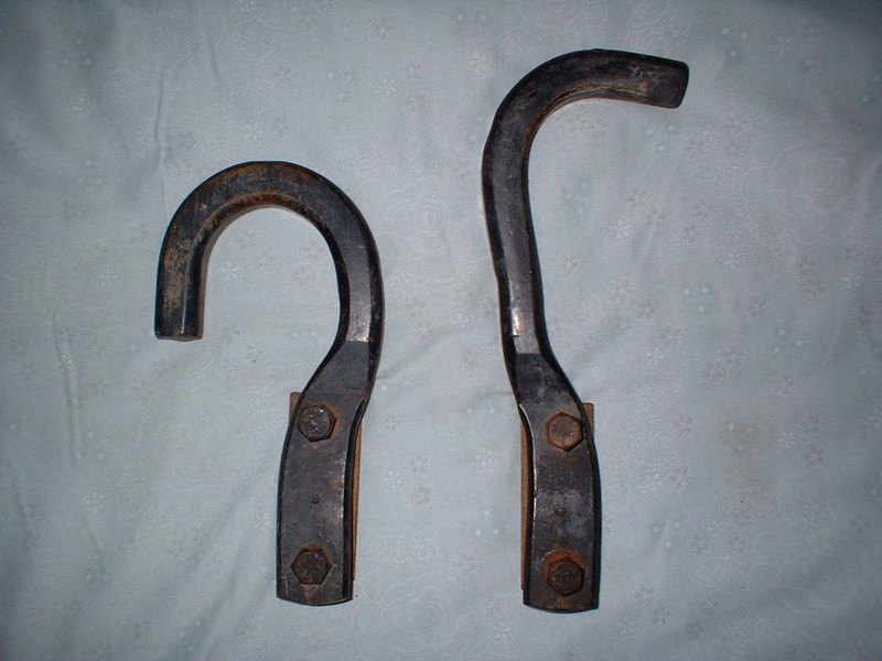 Two metal hooks with bolted bases