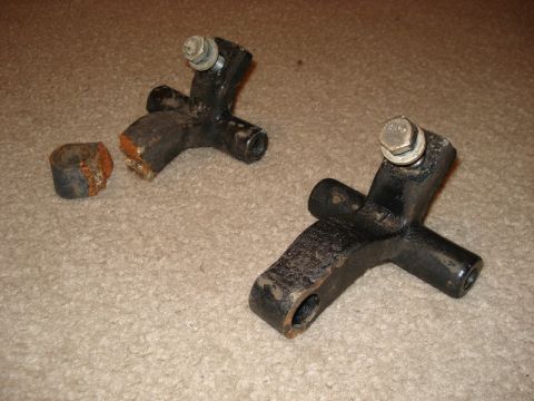 2000 Chevrolet Tahoe - Broken suspension parts and a ring lie on a carpeted surface.