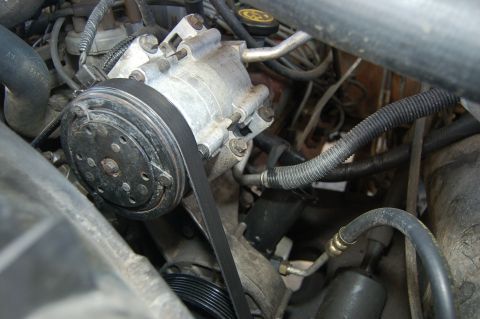 1989 Ford Bronco - This photo shows the air conditioning compressor and belt assembly within a vehicle's engine bay.