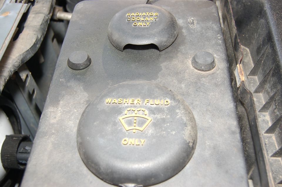 Engine bay fluid reservoirs with text 'RADIATOR COOLANT ONLY' and 'WASHER FLUID ONLY'