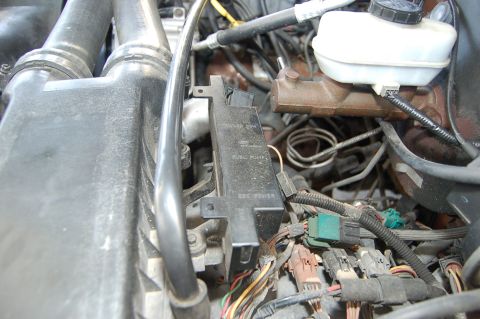 1989 Ford Bronco - Close-up of an engine bay, focusing on the fuse box and brake fluid reservoir.