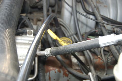 1989 Ford Bronco - A yellow oil dipstick is visible among the complex network of hoses and wires in the engine compartment.