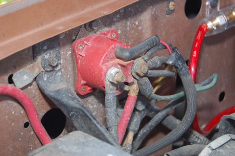 1989 Ford Bronco - Close-up view of the engine bay wiring, a red starter solenoid and red battery cable.