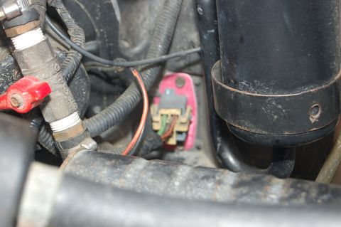 1989 Ford Bronco - A close-up view of various engine components, including wiring and a pink connector with exposed wires.